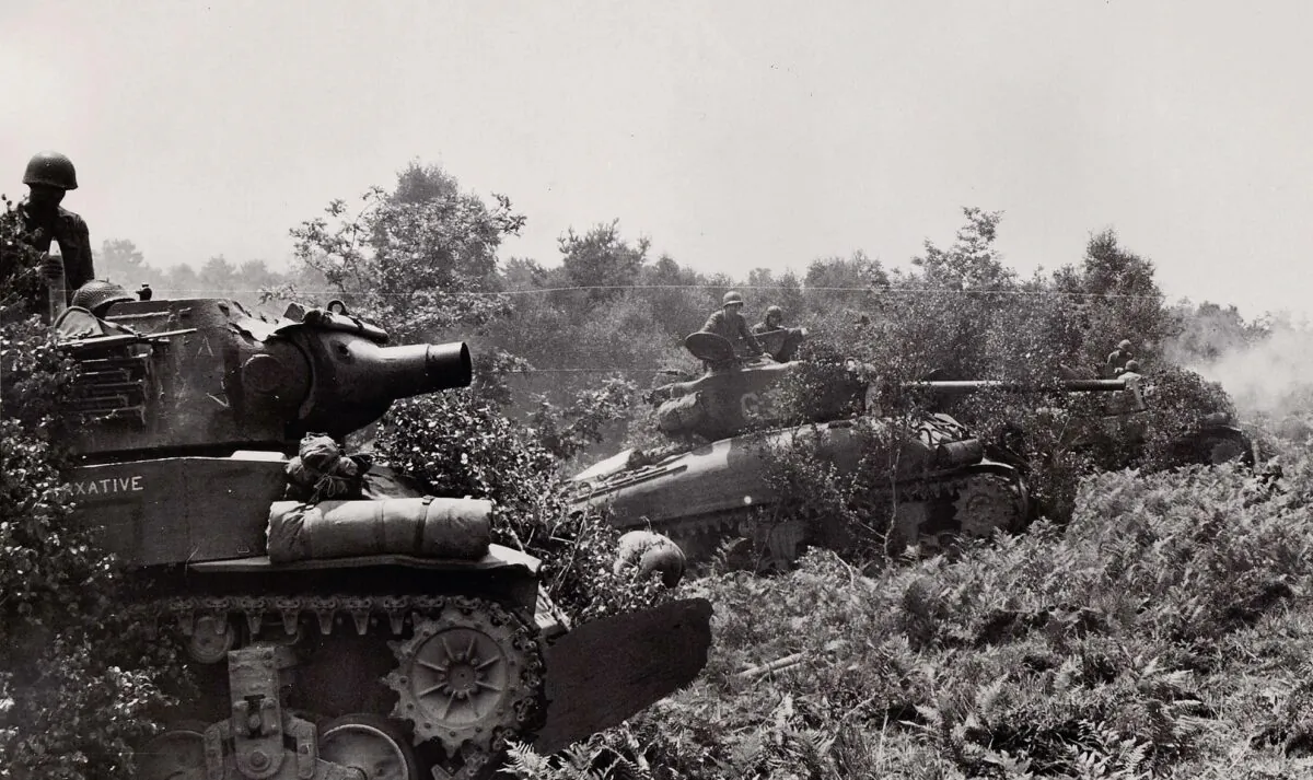 Near Barenton, Normandy,
three Allied armored
vehicles from the U.S. 2nd
Armored Division. In the
foreground, the tank is
equipped with a hedgerow
plow. ( PhotosNormandie (CC BY-SA 2.0, CreativeCommons. org/licenses/by-sa/2.0))