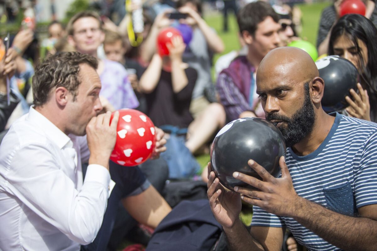 Dozens of protesters stage a mass inhalation of Nitrous Oxide, commonly known as laughing gas, outside the Houses of Parliament in central London, United Kingdom, on Aug.1, 2015. (Jack Taylor/AFP via Getty Images)