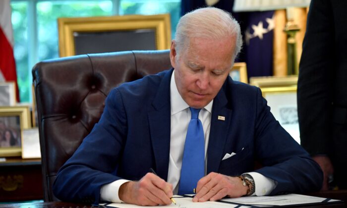 President Joe Biden signs into law the Ukraine Democracy Defense Lend-Lease Act of 2022, in the Oval Office of the White House in Washington on May 9, 2022. (Nicholas Kamm/AFP via Getty Images)