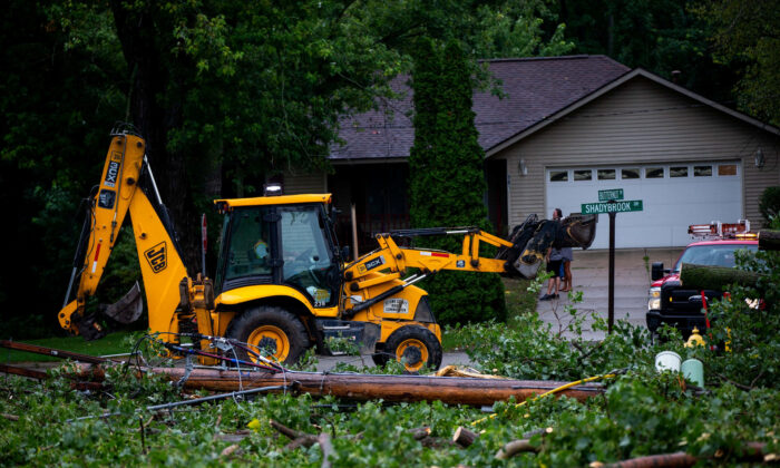 Fallen tree limbs are cleared after thunderstorms and high winds downed power lines and closed roads in Holland, Mich., on Aug. 29, 2022. (Cody Scanlan/Reuters)