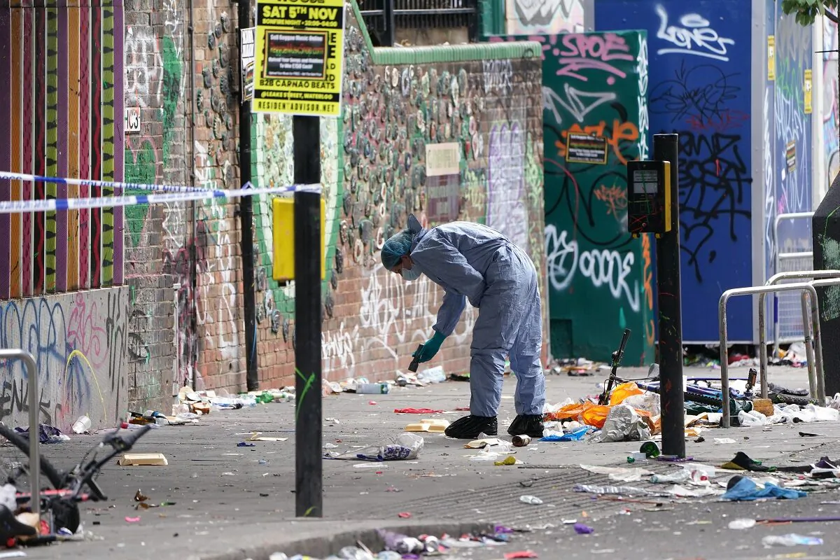 A forensics officer working at the scene where a 21-year-old man was stabbed during the Notting Hill Carnival in Ladbroke Grove, west London, on Aug. 30, 2022. (PA)