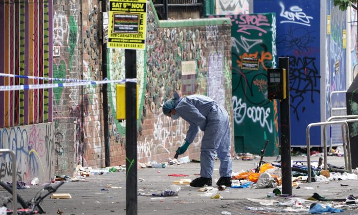 A forensics officer working at the scene where a 21-year-old man was stabbed during the Notting Hill Carnival in Ladbroke Grove, west London, on Aug. 30, 2022. (PA)