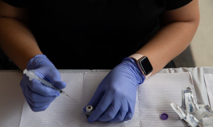 A health care worker prepares a COVID-19 vaccine in Southfield, Mich., on Aug. 24, 2021. (Emily Elconin/Getty Images)