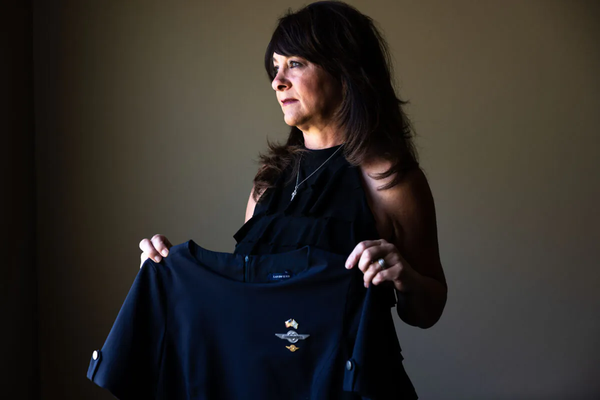 Charlene Carter, who worked for Southwest Airlines as a flight attendant for 21 years before she was fired, holds her former Southwest Airlines flight attendant's uniform at her home in Aurora, Colo., on Aug. 30, 2022. (Michael Ciaglo for The Epoch Times)
