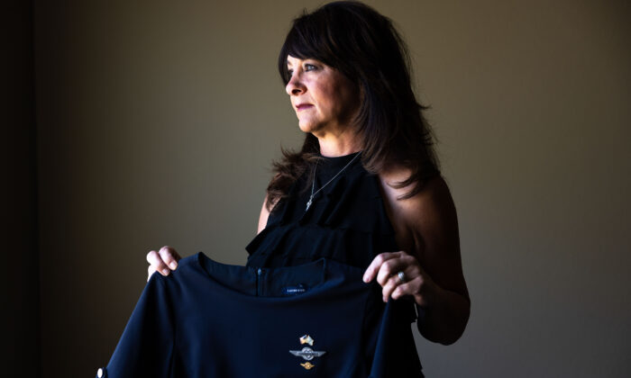 Charlene Carter, who worked for Southwest Airlines as a flight attendant for 21 years before she was fired, holds her former Southwest Airlines flight attendant's uniform at her home in Aurora, Colo., on Aug. 30, 2022. (Michael Ciaglo for The Epoch Times)
