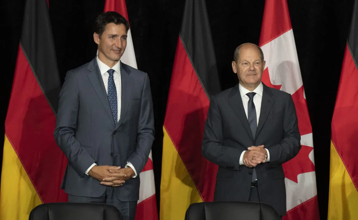 Canadian Prime Minister Justin Trudeau and German Chancellor Olaf Scholz wait for a signing ceremony to begin in Stephenville, Newfoundland and Labrador on Aug. 23, 2022. (The Canadian Press/Adrian Wyld)