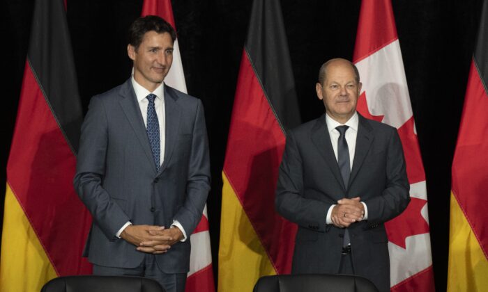 Canadian Prime Minister Justin Trudeau and German Chancellor Olaf Scholz wait for a signing ceremony to begin in Stephenville, Newfoundland and Labrador on Aug. 23, 2022. (The Canadian Press/Adrian Wyld)