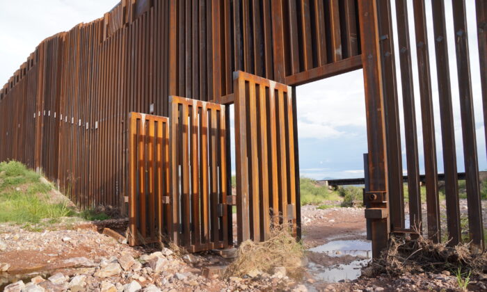 Open gates give easy access into the United States for illegal aliens crossing from Mexico near Douglas, Ariz., on Aug. 24. (Allan Stein/The Epoch Times)