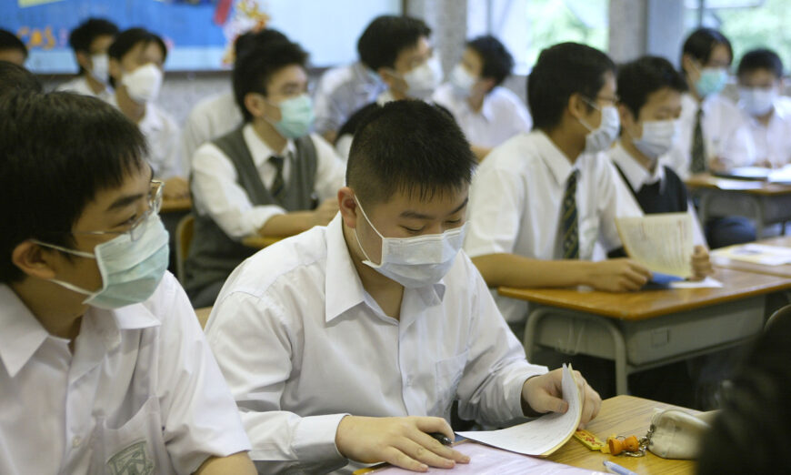 Highschool boys attend class wearing masks in school in Hong Kong on April 22, 2003. (Peter Parks/AFP via Getty Images)