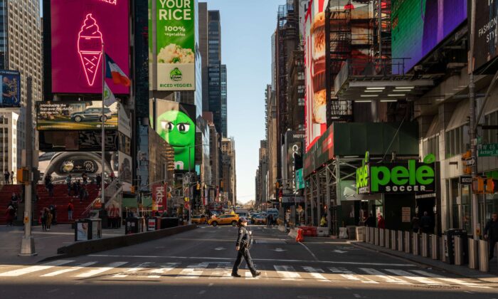2020 年 3 月 12 日，一名警察在纽约几乎空无一人的时代广场过马路。（David Dee Delgado/Getty Images）