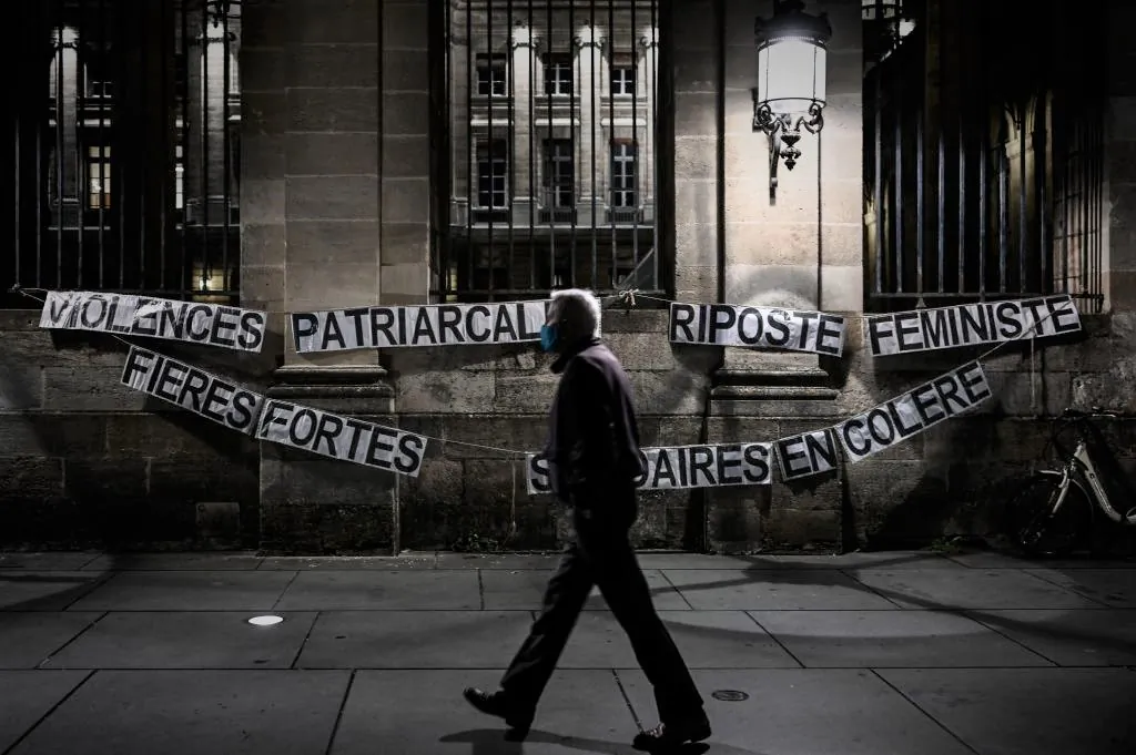 A man walks past a feminist message displayed on the wall of the city hall during a demonstration against patriarchal violence marking the International Day for the Elimination of Violence Against Women in Bordeaux, France, on Nov. 25, 2020. (Philippe Lopez/AFP via Getty Images)