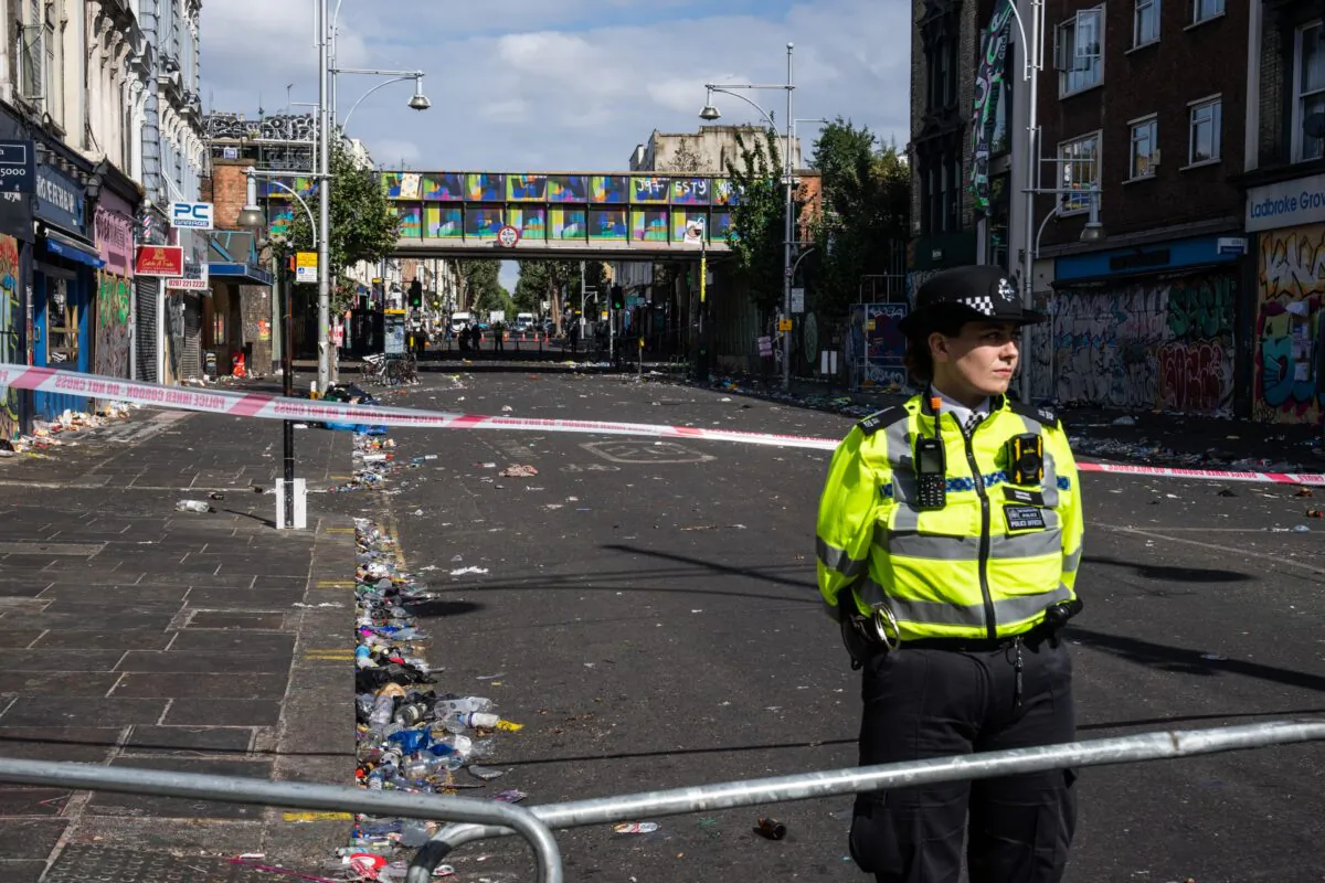 A police officer stands by the cordon at the scene of a fatal stabbing during the Notting Hill Carnival, in the Ladbroke Grove area of London, England, on Aug. 30, 2022. (Carl Court/Getty Images)