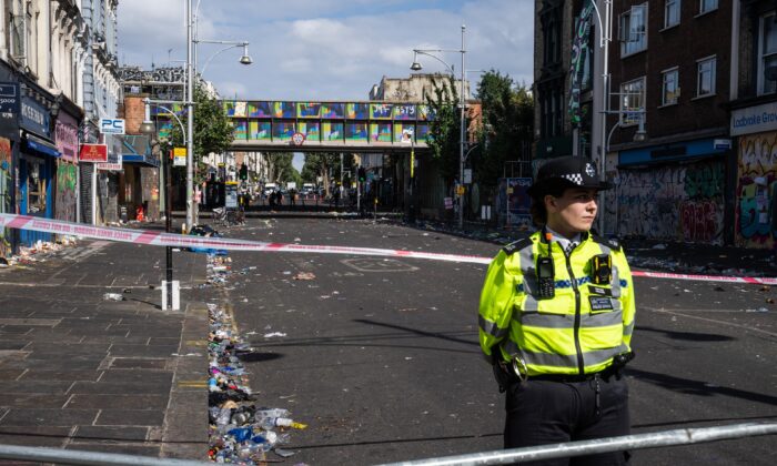 A police officer stands by the cordon at the scene of a fatal stabbing during the Notting Hill Carnival, in the Ladbroke Grove area of London, England, on Aug. 30, 2022. (Carl Court/Getty Images)