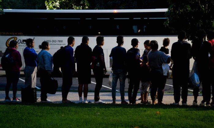 Illegal migrants, who boarded a bus in Texas, listen to volunteers offering assistance after being dropped off within view of the U.S. Capitol building in Washington on Aug. 11, 2022. (Stefani Reynolds/AFP via Getty Images)