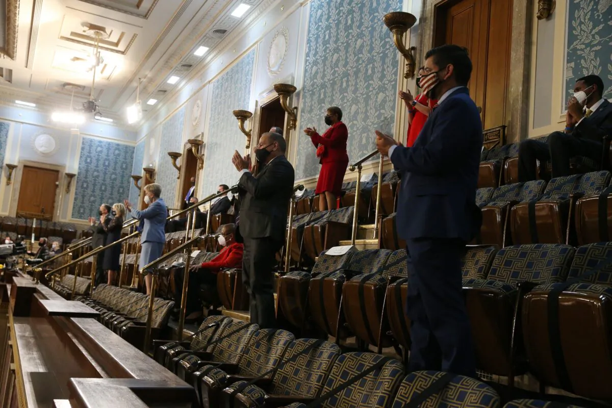 Members of Congress stand in the House of Representatives gallery in Washington on April 28, 2021. (Michael Reynolds/Pool/Getty Images)