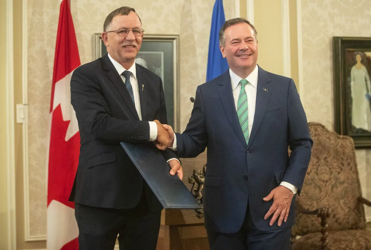 Ron Orr shakes hands with Alberta Premier Jason Kenney during a cabinet shuffle at Government House in Edmonton on July 8, 2021. (The Canadian Press/Jason Franson)