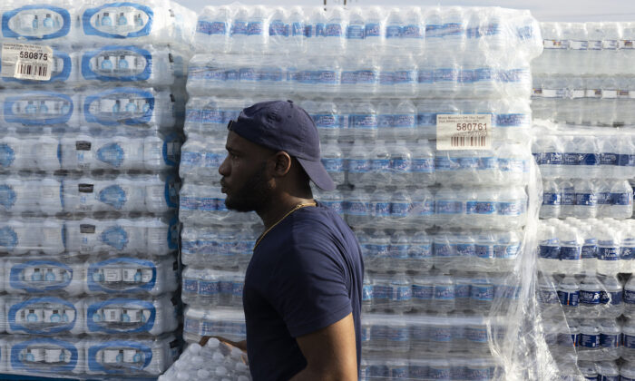 A City of Jackson employee helps hand out cases of bottled water at a Mississippi Rapid Response Coalition distribution site in Jackson, Mississippi, on Aug. 31, 2022. (Brad Vest/Getty Images)