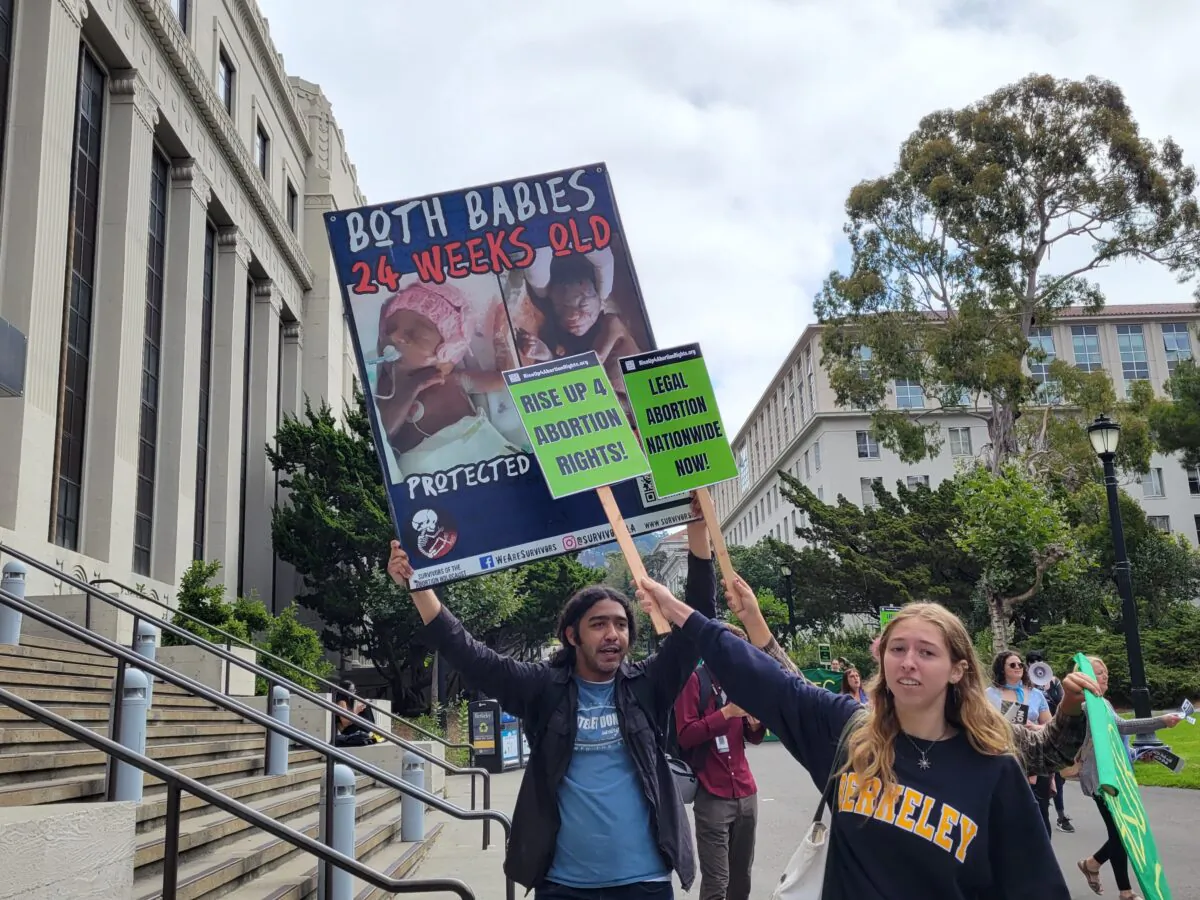 Robert Byrd of Pro-Life San Francisco holds up a sign while Rise Up 4 Abortion Rights counter-protesters block part of it at University of California Berkeley on Aug. 26, 2022. (Jason Blair/The Epoch Times)
