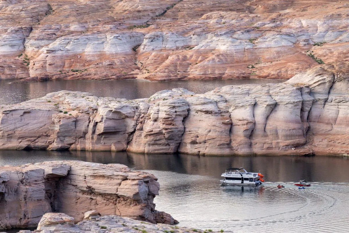 A boat makes its way through rock formation becoming increasingly visible as Lake Powell recedes, near the Glen Canyon Dam on the Colorado River in Page, Ariz., on Sept. 1, 2022. (ROBYN BECK/AFP via Getty Images)