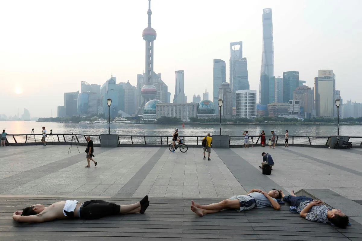 People sleeping on the waterfront to keep cool in Shanghai, on July 25, 2017. (STR/AFP via Getty Images)