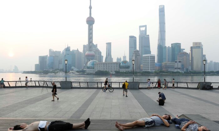 People sleeping on the waterfront to keep cool in Shanghai, on July 25, 2017. (STR/AFP via Getty Images)