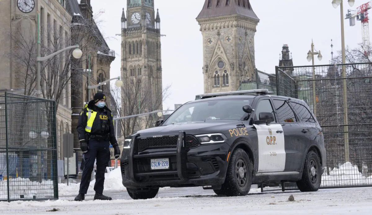 A police officer stands at a checkpoint near Parliament Hill on Feb. 23, 2022 in Ottawa. (The Canadian Press/Adrian Wyld)