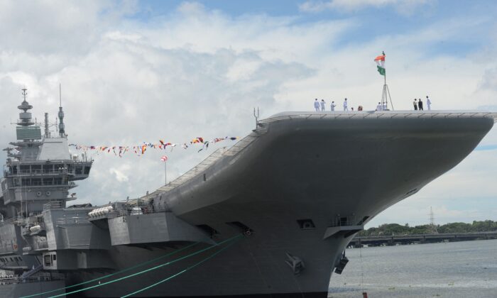 2022 年 9 月 2 日，印度本土航空母舰 INS Vikrant 在印度高知的科钦造船厂进行调试期间，印度海军军官聚集在甲板上。-印度首次亮相本地制造的航空母舰，这是政府努力减少航空母舰的里程碑它对外国武器的依赖，并对抗中国在该地区日益增长的军事自信。  （阿伦桑卡尔/法新社通过盖蒂图片社）