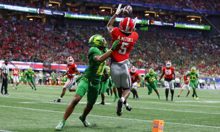 Adonai Mitchell (5) of the Georgia Bulldogs catches a pass for a touchdown over Christian Gonzalez #0 of the Oregon Ducks during the second half at Mercedes-Benz Stadium in Atlanta, on Sept. 3, 2022. (Todd Kirkland/Getty Images) 
