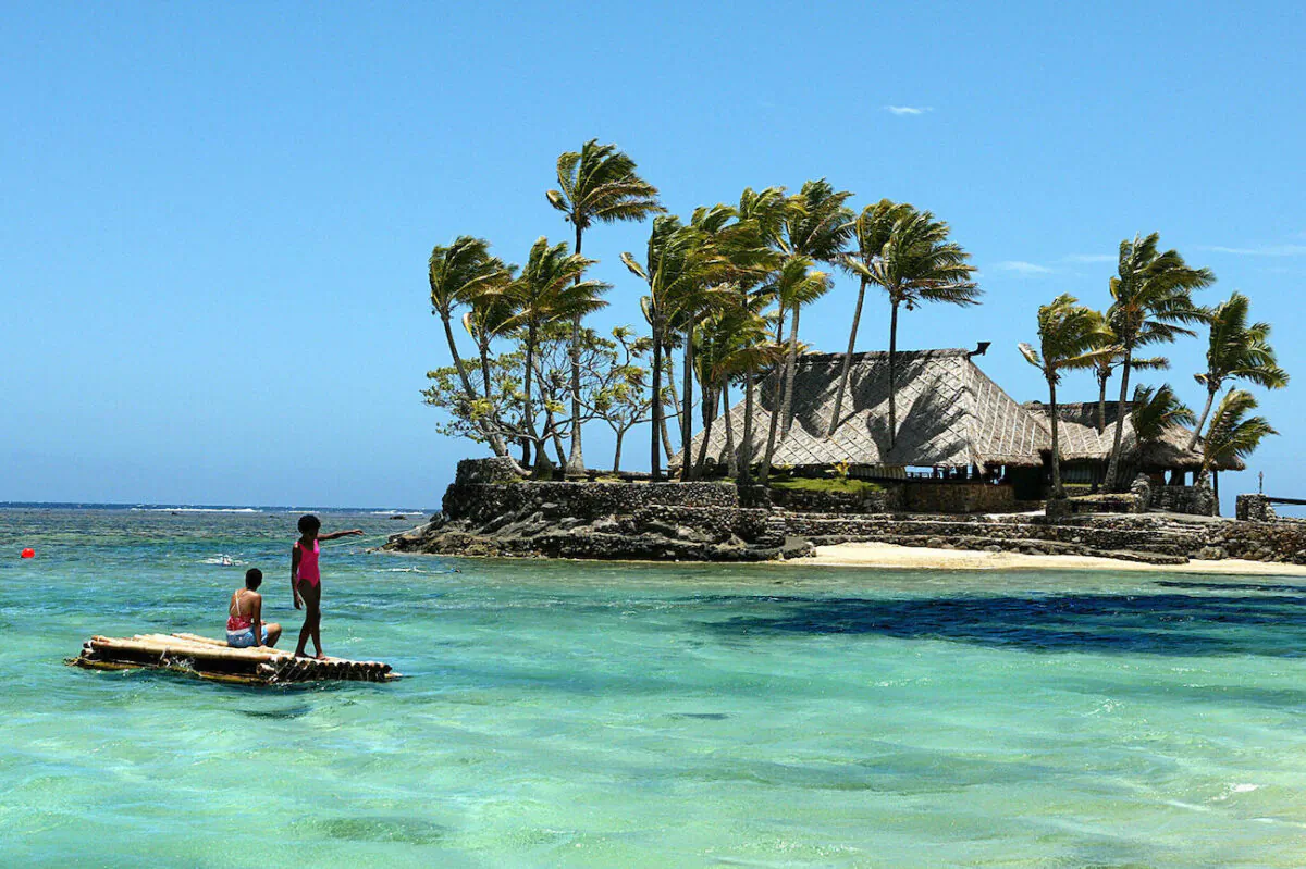 Melanesian children float on a bamboo pontoon on the resort-studded Coral Coast of Fiji on Nov. 11, 2003. (Torsten Blackwood/AFP via Getty Images)