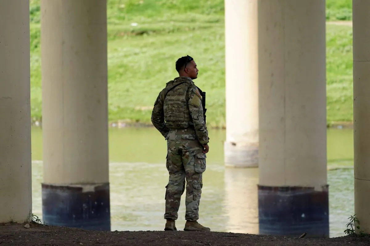 A member of the Texas National Guard looks across the Rio Grande to Mexico from the United States at Eagle Pass, Texas, on Aug. 26, 2022. (Eric Gay/AP Photo)