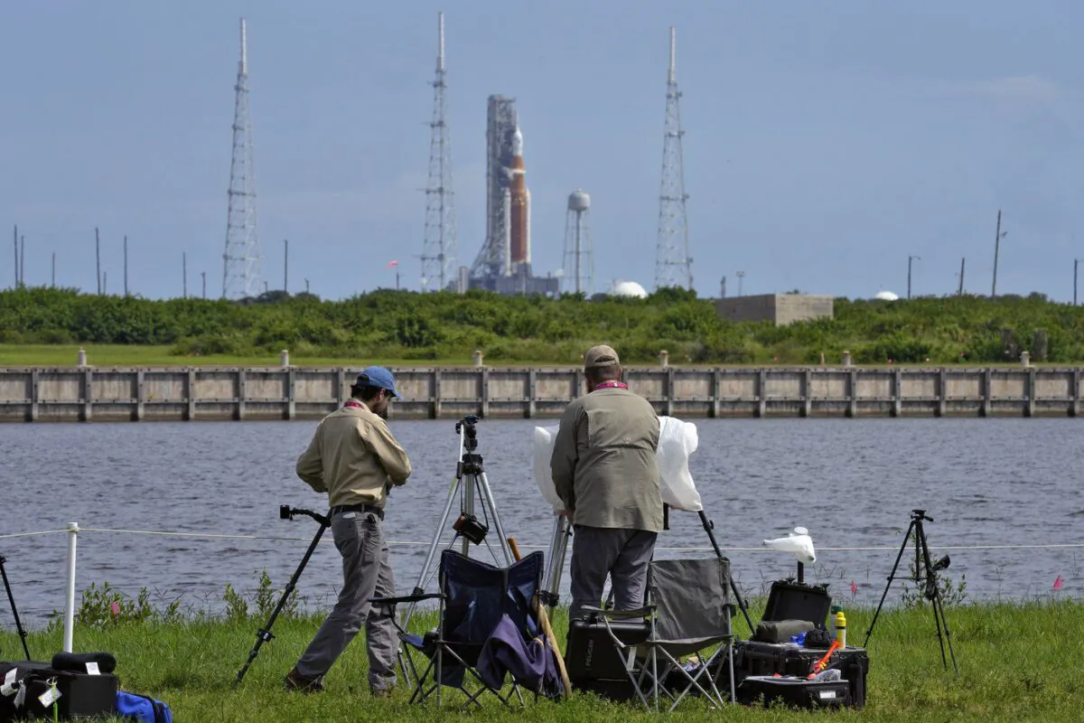 Photographers pack up their equipment as NASA's new moon rocket sits on Launch Pad 39-B after being scrubbed at the Kennedy Space Center, in Cape Canaveral, Fla., Sept. 3, 2022. (The Canadian Press/AP-Chris O'Meara)