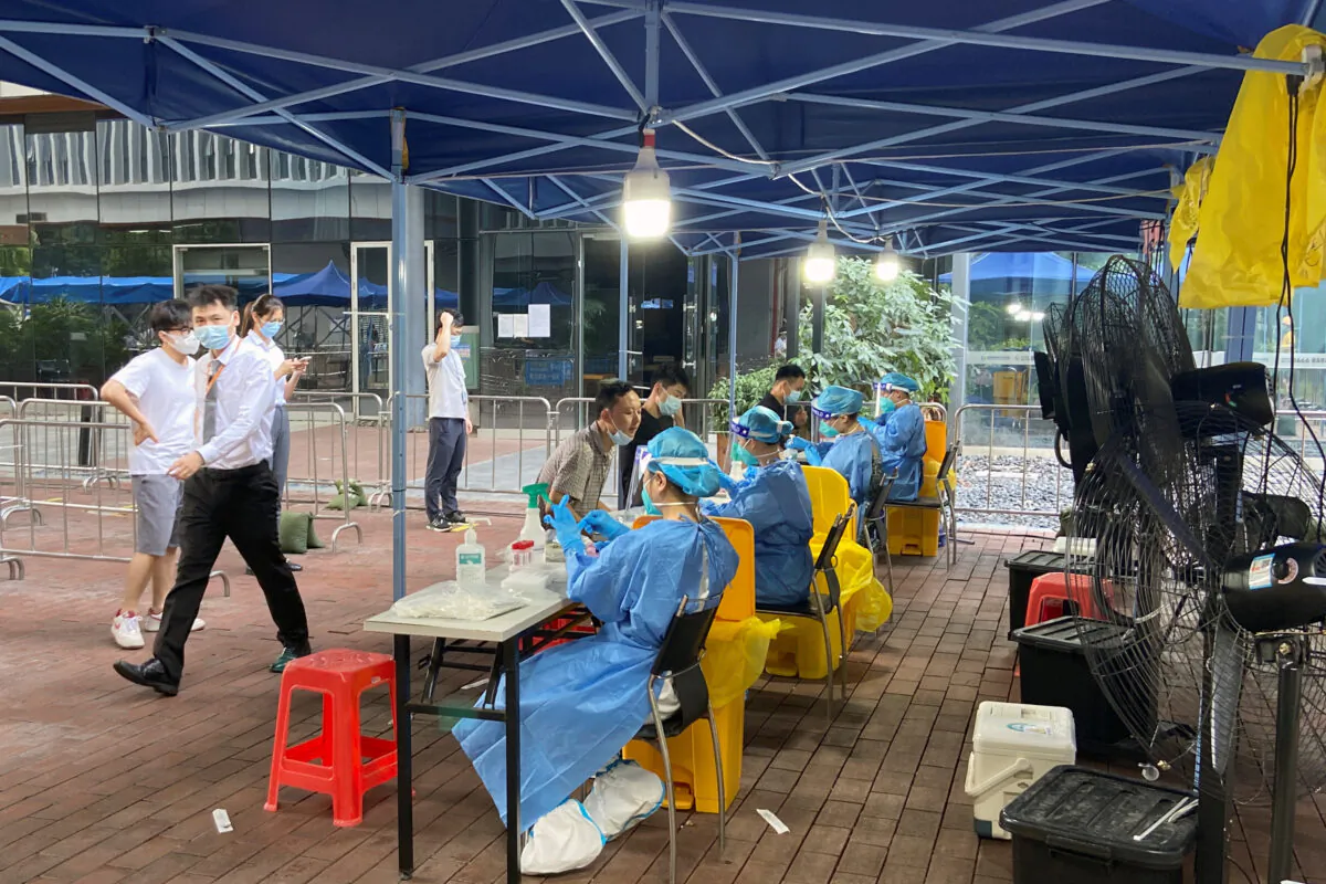 Medical workers in protective suits collect swabs at a nucleic acid testing site at the Software Park in Nanshan district, Shenzhen, Guangdong province, China, on Sept. 2, 2022. (David Kirton/Reuters)