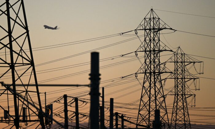 An aircraft takes off from Los Angeles International Airport behind electric power lines in El Segundo, Calif., on Aug. 31, 2022. (Patrick T. Fallon/AFP via Getty Images)