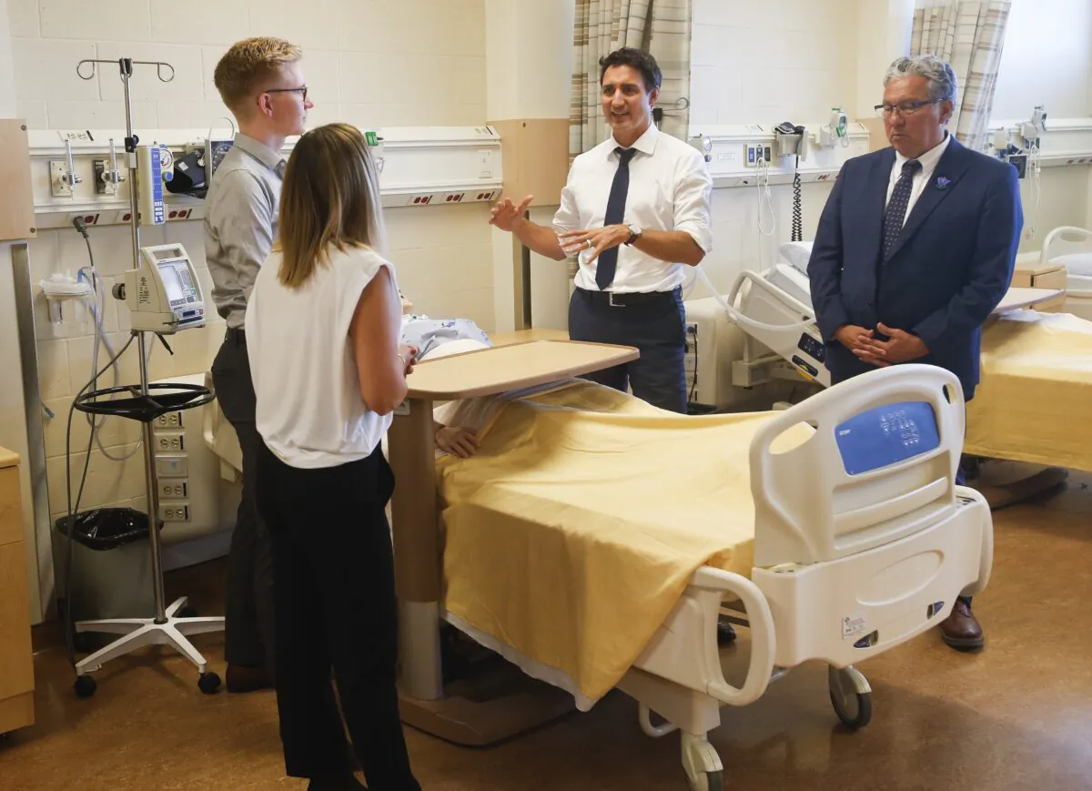 Prime Minister Justin Trudeau and Minister of Northern Affairs, Dan Vandal, visit with nursing students, Rene Piche and Diane Pineau, at the School of Nursing in the St Boniface University in Winnipeg, on Sept. 1, 2022. (John Woods/The Canadian Press)