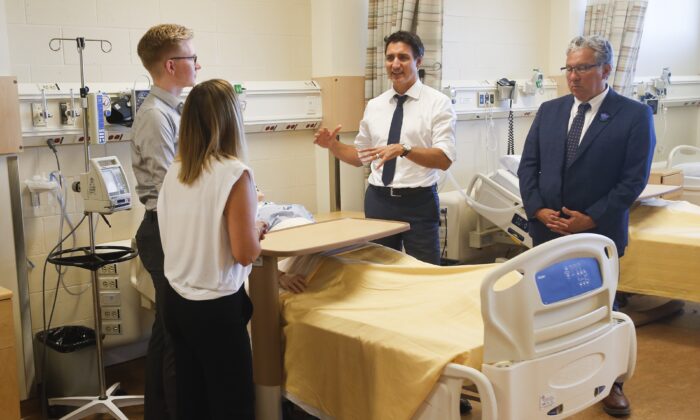 Prime Minister Justin Trudeau and Minister of Northern Affairs, Dan Vandal, visit with nursing students, Rene Piche and Diane Pineau, at the School of Nursing in the St Boniface University in Winnipeg, on Sept. 1, 2022. (John Woods/The Canadian Press)