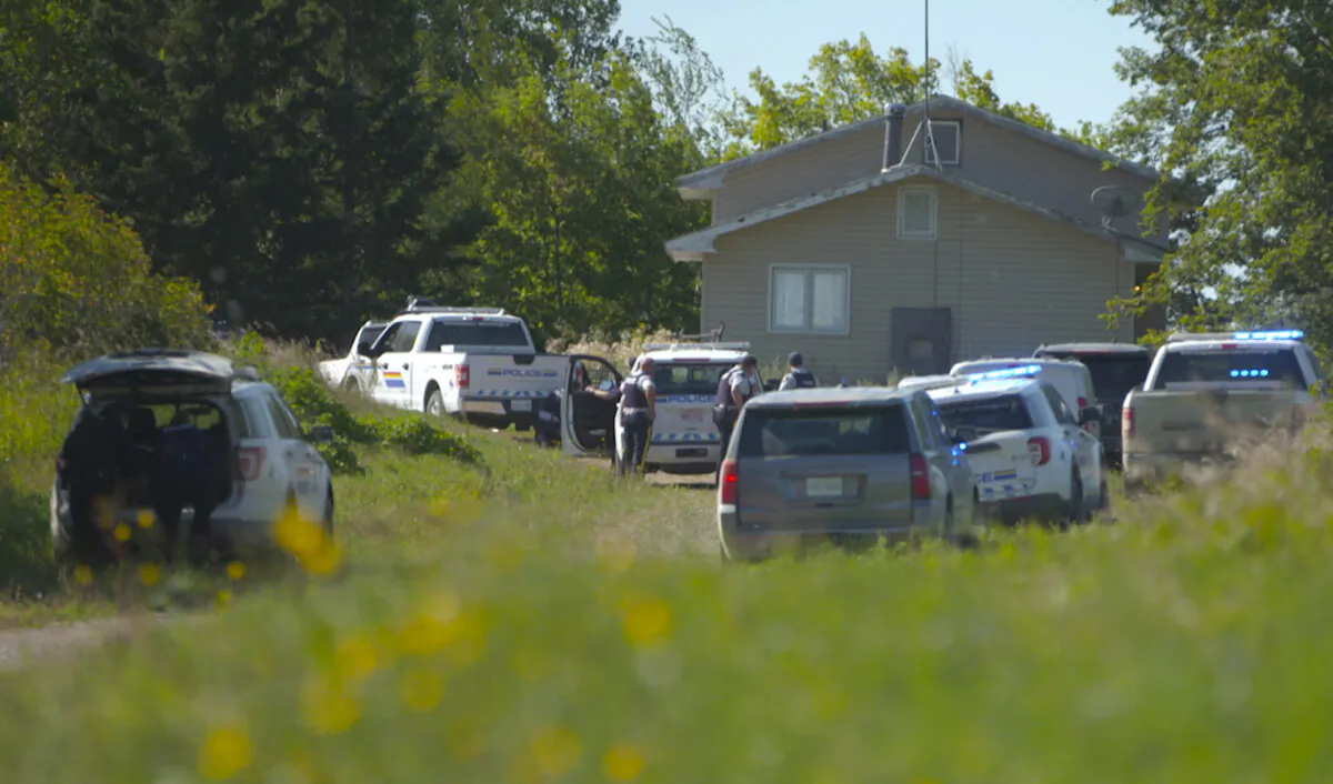 In this image taken from video, Canadian law enforcement personnel surrounded a residence on the James Smith Cree First Nation reservation in Saskatchewan, Canada, Sept. 6, 2022, as they search for a suspect in a series of stabbings. (AP Photo/Robert Bumsted)