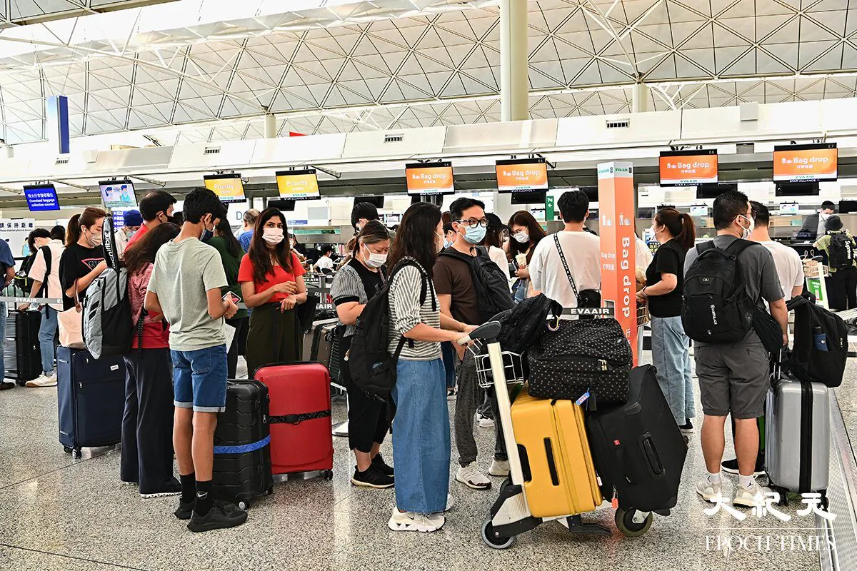 Travelers wait to check in luggage for departure at Hong Kong International Airport. (Terence Tang/The Epoch Times)