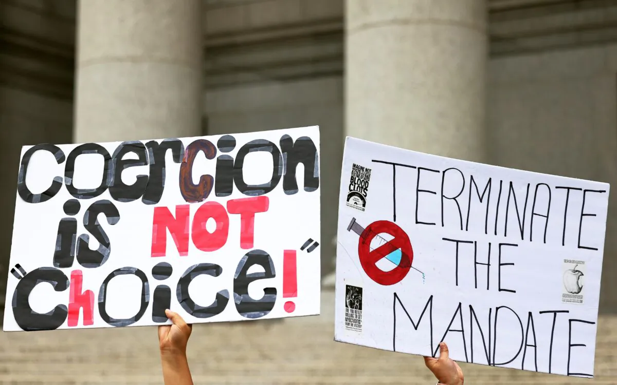 A person holds up a signs as people hold a rally in support of a group of teachers fighting enforcement of the COVID-19 vaccine mandate for public school employees at Thurgood Marshall United States Courthouse, in New York City, on Oct. 12, 2021. (Michael M. Santiago/Getty Images)