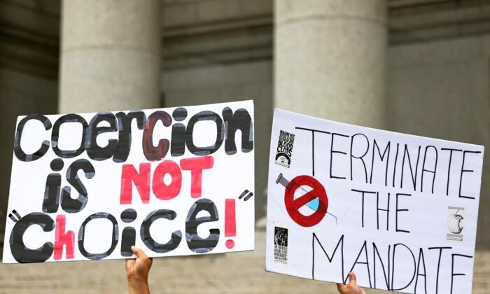 A person holds up a signs as people hold a rally in support of a group of teachers fighting enforcement of the coronavirus (COVID-19) vaccine mandate for public school employees at Thurgood Marshall United States Courthouse, in New York City, on Oct. 12, 2021. (Michael M. Santiago/Getty Images)