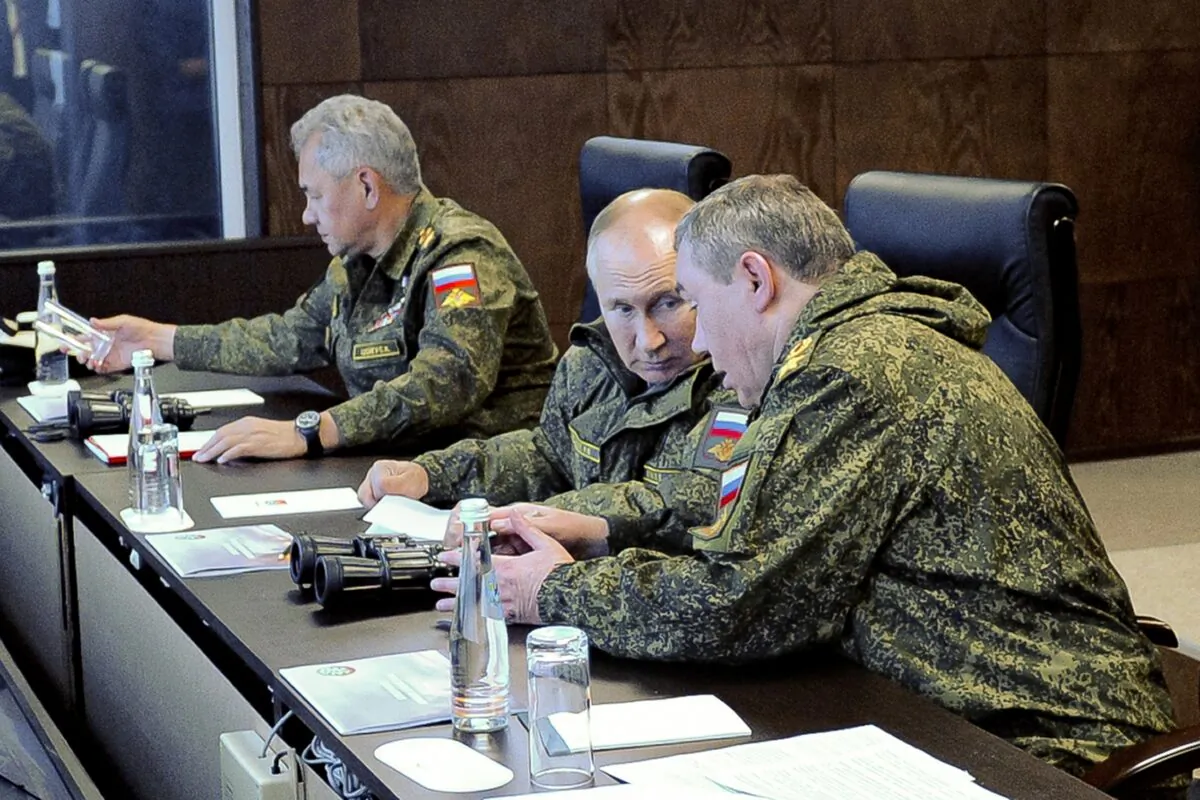 Russian President Vladimir Putin (C) speaks to General Staff chief Gen. Valery Gerasimov (R) as Defense Minister Sergei Shogu sits (L) during the Vostok 2022 (East 2022) military exercise outside Vladivostok in far eastern Russia on Sept. 6, 2022. (Mikhail Klimentyev, Sputnik, Kremlin Pool Photo via AP)
