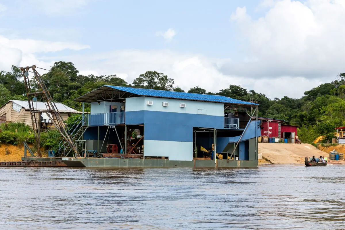 A boat sails by a free-service shop along the Maroni river on the Suriname coast side, on Jan. 20, 2019. (Jody Amiet/AFP via Getty Images)