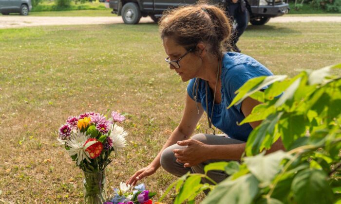 Ruby Works places flowers at the home of a victim who has been identified by residents as Wes Petterson in Weldon, Sask., on Sept. 5, 2022. (The Canadian Press/Heywood Yu)