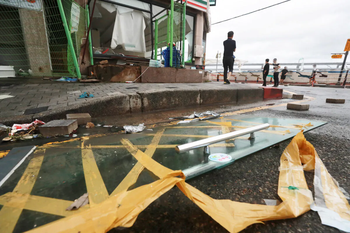 People stand at a shopping district damaged by Typhoon Hinnamnor in Busan, South Korea, on Sept. 6, 2022. (Yonhap/via Reuters)