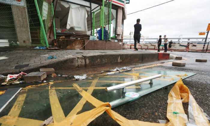 People stand at a shopping district damaged by Typhoon Hinnamnor in Busan, South Korea, on Sept. 6, 2022. (Yonhap/via Reuters)