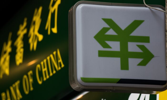 A Chinese yuan currency sign with two arrows is pictured outside a bank branch of the People’s Bank of China in Shanghai on Aug. 13, 2015. (Johannes Eisele/AFP via Getty Images)