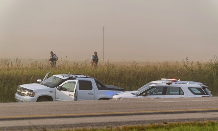 Police and investigators gather at the scene where stabbing suspect Myles Sanderson was arrested in Rosthern, Saskatchewan, on Sept. 7, 2022. (Heywood Yu/The Canadian Press via AP)