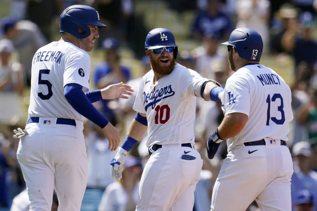 Los Angeles Dodgers' Justin Turner, center, celebrates his three-run home run at home plate with Max Muncy (13) and Freddie Freeman (5) during the fifth inning of a baseball game against the San Francisco Giants in Los Angeles Dodgers rally past the San Francisco Giants in Los Angeles, on Sept. 7, 2022. (Marcio Jose Sanchez/AP Photo)