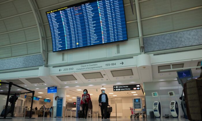 Travelers are photographed at Toronto Pearson International Airport, on December 16, 2021. (The Canadian Press /Tijana Martin)