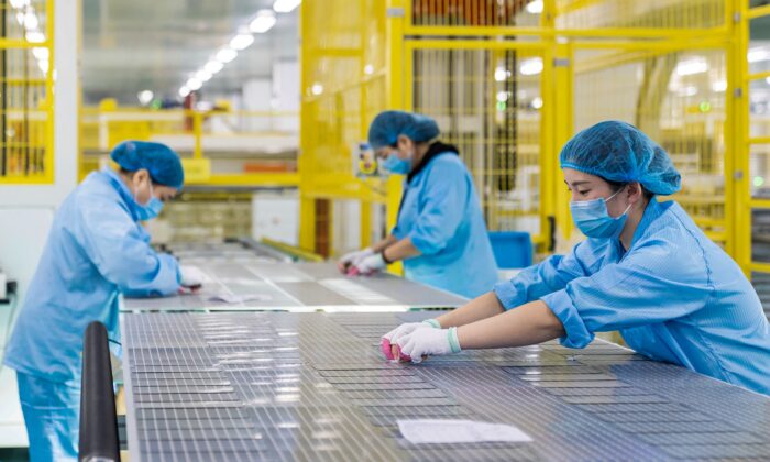 Workers are making solar photovoltaic modules used for small solar panels at a factory in Haian in China's eastern Jiangsu Province on Jan. 7, 2022. (STR/AFP via Getty Images)