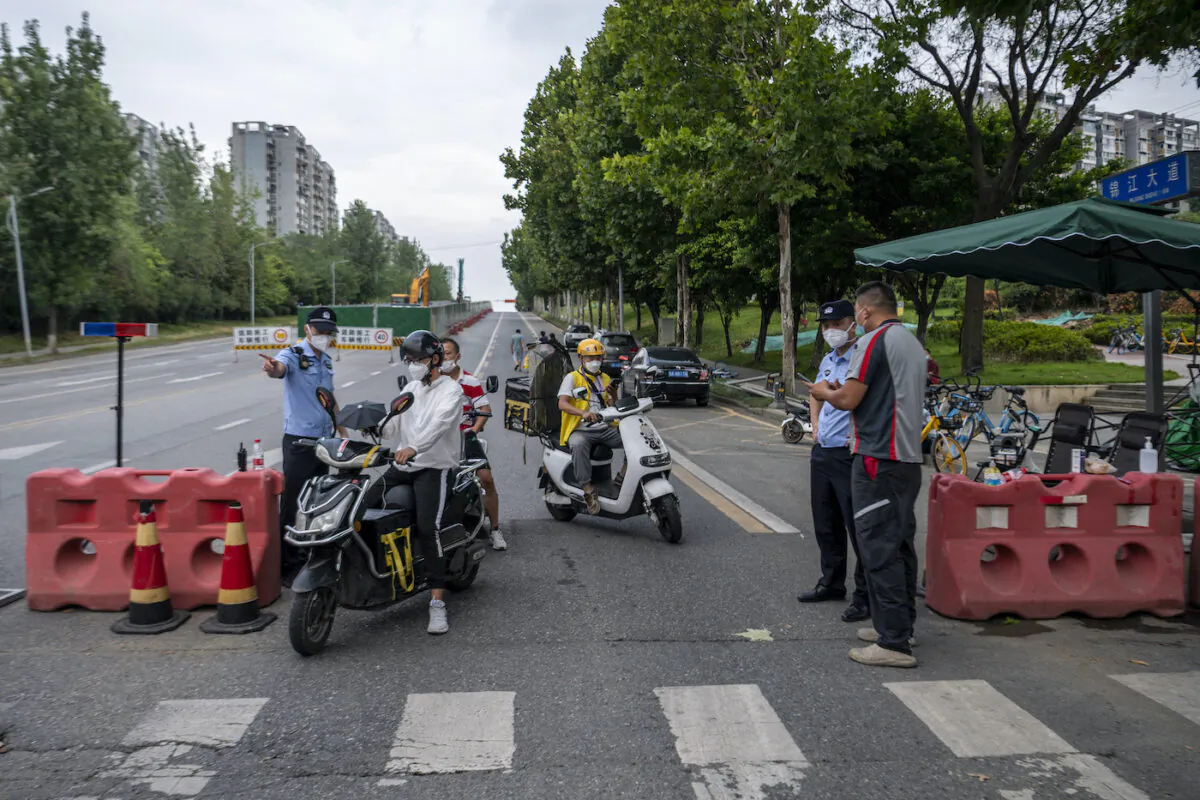 Police officers check people’s information at a roadblock on Sept.1, 2022, amid restrictions due to an outbreak of COVID-19 in Chengdu, southwestern Sichuan Province, China. (CNS/AFP via Getty Images)